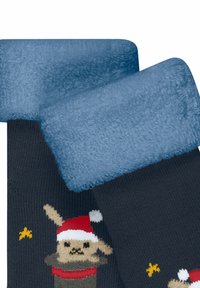 Dunkelblaue Socken mit einem plüschigen hellblauen Bund, der mit einem cartoonhaften Bären dekoriert ist, der einen Weihnachtsmann-Hut und ein rotes Sweatshirt trägt.