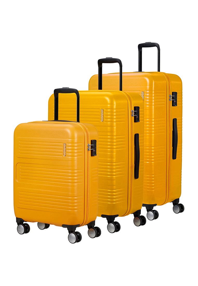 Drei gelbe Hartschalenkoffer in unterschiedlichen Größen, mit geriffelten Designs, schwarzen Griffen und vier multidirektionalen Rädern.
