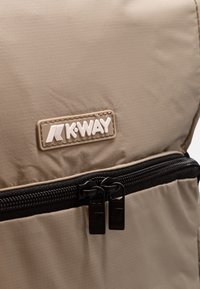 Zaino in nylon beige con logo K-Way, superficie testurizzata, zip nera e doppie zip per un facile accesso.