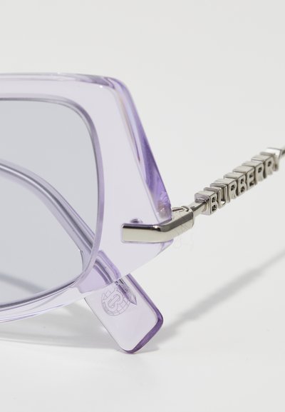 Violetti ylisuuria aurinkolaseja, joissa on läpikuultavat kehykset, harmaat linssit ja hopeanväriset metalliset yksityiskohdat, joissa on "Burberry"-logo varrella.