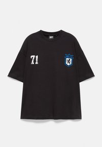 T-shirt noir à manches courtes avec le numéro blanc 71 sur la poitrine gauche et un blason bleu avec un lion sur la poitrine droite.