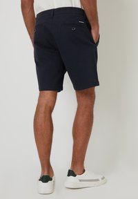Marineblå shorts i et afslappet design med sidelommer, baglommer med knap og en glat, let stofstruktur.