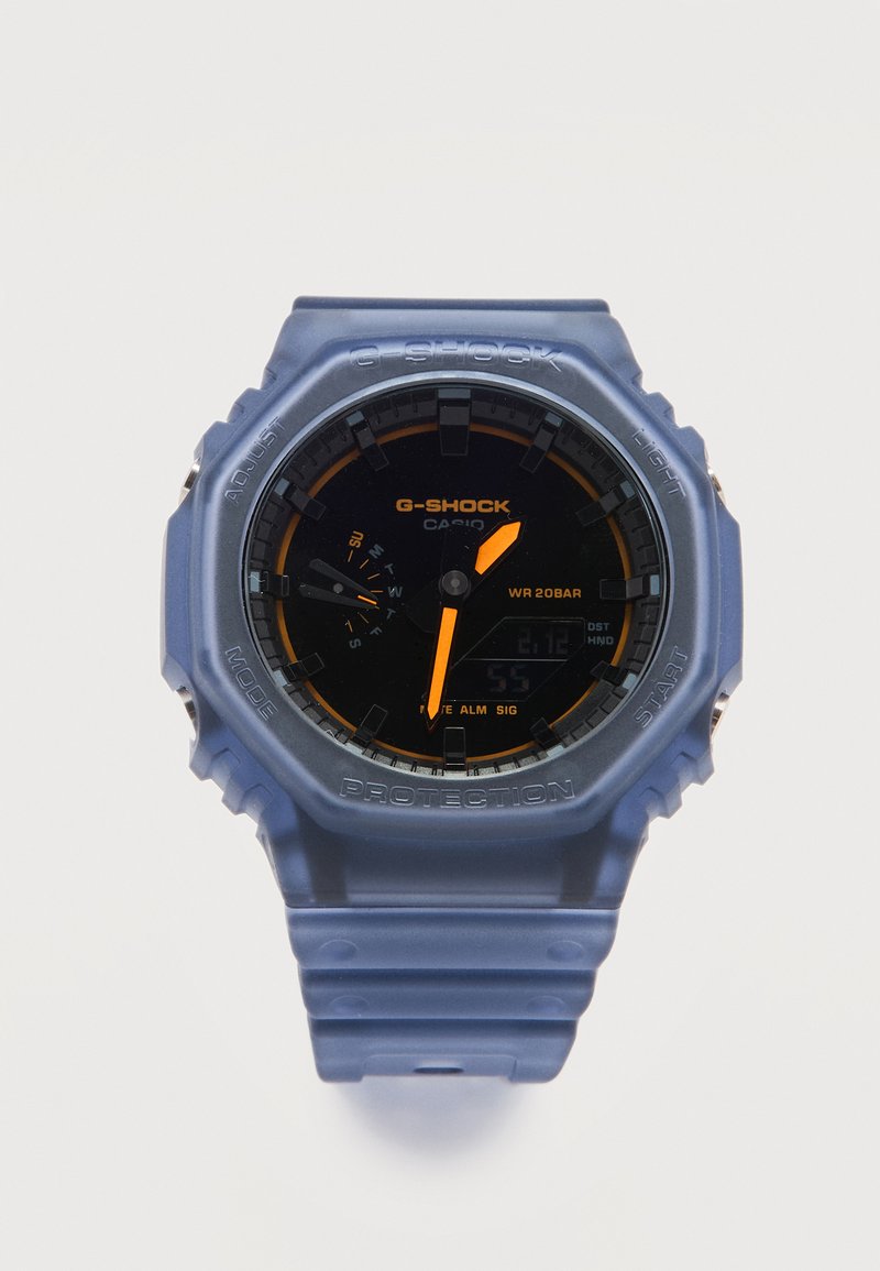 Μπλε ρολόι χειρός Casio G-Shock με μαύρο καντράν, πορτοκαλί δείκτες, ένδειξη ημέρας, ψηφιακή οθόνη και ανθεκτικό προστατευτικό σχέδιο.