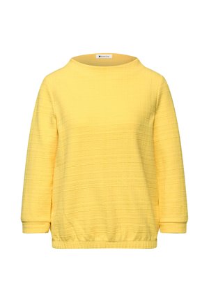 Maglietta a maniche lunghe di colore giallo con una trama, scollo tondo ed elastico in vita, mostrata su sfondo bianco.