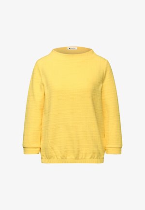 Maglietta a maniche lunghe di colore giallo con una trama, scollo tondo ed elastico in vita, mostrata su sfondo bianco.