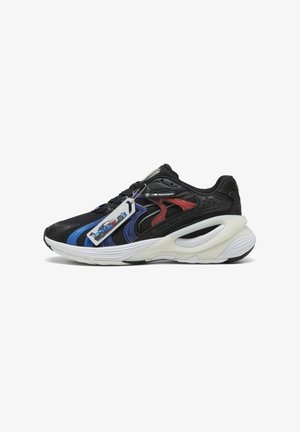 Baskets de sport noires avec des accents bleus et rouges, dotées d'une tige en tissu texturé et d'une semelle intermédiaire blanche distinctive. Comprend une étiquette avec des graphiques.