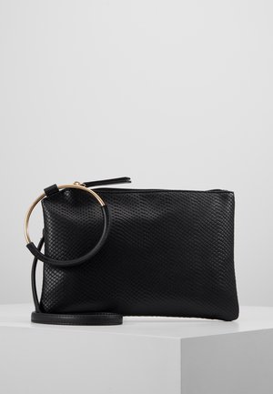 Schwarze strukturierte Clutch-Tasche mit goldenem rundem Griff und abnehmbarem Handgelenksriemen auf weißer Oberfläche.