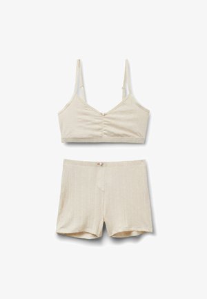 Beige ribstrikket to-delt sæt med justerbar spaghetti-strop crop top og matchende shorts med høj talje og knapdetaljer.