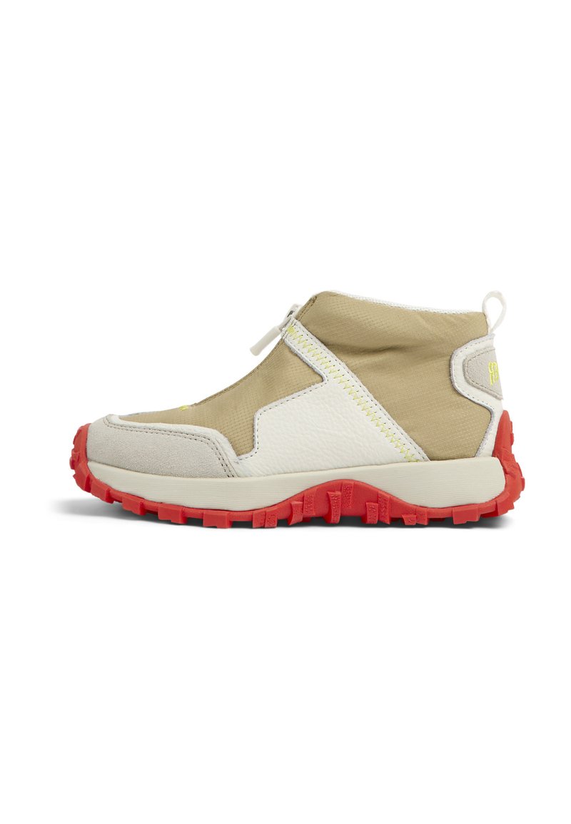 Baskets mi-hautes beiges et blanches avec une tige texturée, semelle en caoutchouc rouge et fermeture éclair sur le côté. Présente un accent jaune et des détails cousus.