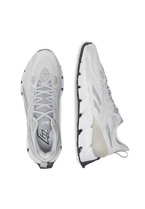 Jasnoszare buty sportowe z siateczkową cholewką, cienkimi sznurowadłami i teksturowaną gumową podeszwą. Posiadają plastikowe akcenty oraz wyraźny wzór bieżnika.