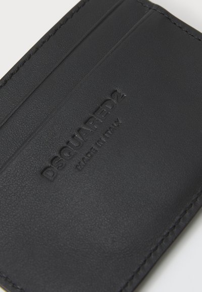 Black leather cardholder featuring embossed logo, multiple card slots, and visible stitching along the edges. Smooth texture, minimalist design.