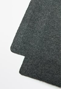 Tissu texturé gris foncé avec un motif tissé, présentant deux pièces superposées aux bords droits et légèrement effilochés.