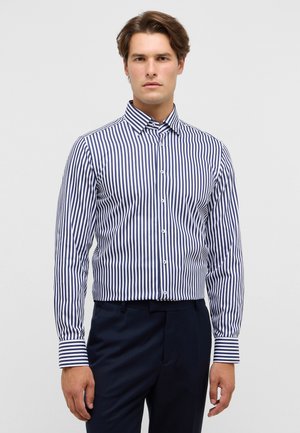 Navy en witte gestreepte overhemd met lange mouwen, met een knoopsluiting bij de kraag, slim fit ontwerp, gladde textuur, gecombineerd met donkere broek.