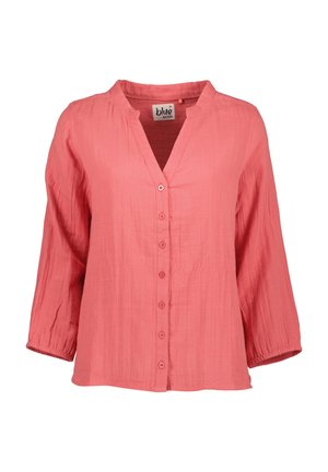 Korallinpunainen pitkähihainen pusero, jossa napit edessä ja pieni pystykaulus, valmistettu kevyestä teksturoidusta kankaasta.