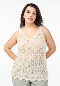 Beige gestricktes Tanktop mit Zickzackmuster, V-Ausschnitt und gewelltem Saum, aus einem atmungsaktiven, luftigen Material gefertigt.