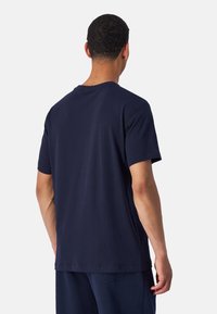 Navyblauwe katoenen T-shirt met korte mouwen, een ronde hals en een rechte zoom zichtbaar vanuit de achterkant, met minimale stikseldetails.