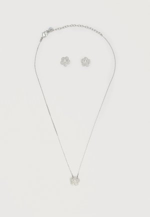 Silberne Halskette und passendes Ohrring-Set mit blumenförmigen Anhängern, die zentrale Perlen und kleine umgebende Kristalle zeigen.