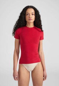 T-shirt aderente rossa in cotone, con maniche corte e colletto rotondo classico, dalla consistenza liscia e senza motivi visibili.