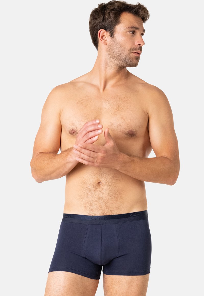 Boxer-culottes bleu marine en tissu doux, dotées d'une ceinture élastique confortable avec un branding discret, présentant un design ajusté.