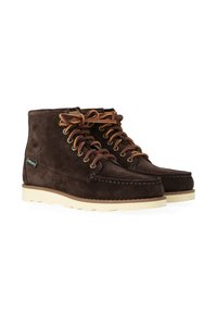 Stivaletti alla caviglia in suede marrone con suole in gomma bianca, dotati di lacci marroni, occhielli in metallo e un piccolo etichetta del marchio sul lato.