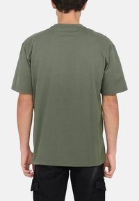 Olive green cotton t-shirt, short sleeves, relaxed fit, round neckline, minimal design, smooth texture, no visible branding or patterns.