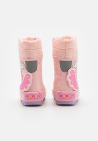 Stivali impermeabili rosa con una finitura lucida, accentuati da nuvole e farfalle, e motivi a stella sui lati. Presentano una parte superiore imbottita e una suola testurizzata.