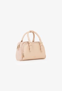 Borsa a mano in pelle beige con due manici, tasca frontale con zip e hardware in tonalità oro su sfondo bianco.