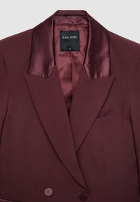 Maroon double-breasted blazer with satin lapels and a black Calliope brand label inside the collar, size small.