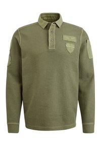 Grünes langärmliges Poloshirt mit Kragen, ausgestattet mit drei Knöpfen. Strukturierter Stoff, Schulterstücke und Embleme auf der Brust.