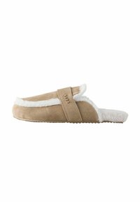 Beige suède slipper met een zachte witte bontvoering, open achterkant en een brede band over de bovenkant met een klein logo. Gestructureerde zool voor grip.