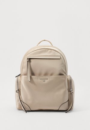 Beige Michael Kors rugzak met voorvak met rits, twee zijvakken met rits, bovenhandvat en subtiel logo centraal aan de voorkant.