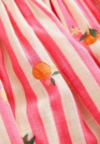 Tissu en coton à rayures verticales roses et blanches et petits motifs de fruits orange avec des feuilles vertes et des fleurs jaunes.