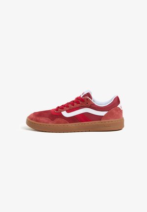 Red suede sneaker with white side stripes and laces, tan rubber sole. Features rounded toe and padded collar for comfort.