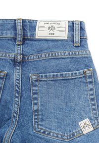 Back view of blue denim jeans showing back pocket, belt loops, and white label with "Band of Rascals Denim" branding.