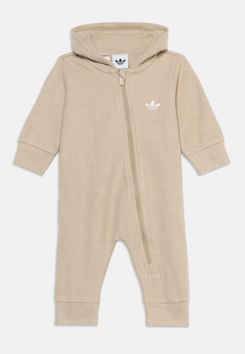 Combinaison bébé côtelée beige avec capuche, manches longues, fermeture éclair diagonale à l'avant et petit logo blanc Adidas sur la poitrine.