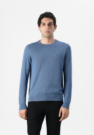 Blauer Rundhalsausschnitt-Pullover aus glattem Strick mit gerippten Bündchen und Saum; verfügt über ein kleines Logo auf der Brust und eine taillierte Silhouette.