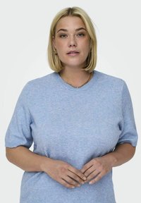 Svetlo modra kratka majica s kratkimi rokavi in okroglim izrezom, izdelana iz mehke tkanine. Ima subtilno teksturo in rebraste manšete.