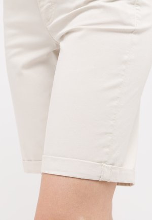 Beige Baumwollshorts mit umgeschlagenem Saum, die über eine glatte Textur und seitliche Taschen verfügen, entworfen für lässige Freizeitkleidung.