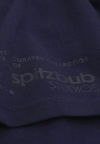 Navy T-shirt with a smooth texture displaying a printed logo reading "spitzbub STUDIOS" in light gray, positioned near the hem.