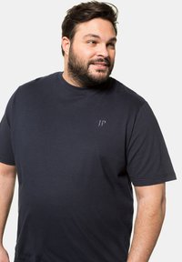 Dunkelblaues T-Shirt mit kurzen Ärmeln aus Baumwolle, mit einem runden Ausschnitt und einem kleinen Logo im linken Brustbereich.