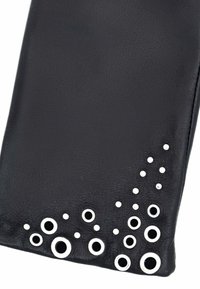 Pochette en cuir noir avec une surface texturée, ornée de grappes de décorations circulaires blanches de tailles variées dans le coin inférieur.