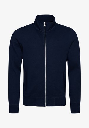 Laivaston vetoketjullinen huppari, jossa on korkea kaula, ribattu hihansuu ja helma, sivutaskut sekä hienovarainen brändilogo rinnassa. Pehmeä kankaan rakenne.