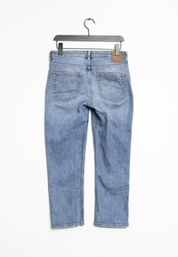 Jeans in denim blu chiaro appesi a un gancio nero, con design a gamba dritta, due tasche posteriori e una toppa in pelle marrone in vita.