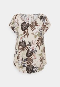 Blouse à manches courtes en tissu beige avec un motif floral tropical comportant des feuilles vertes et brunes, des fleurs blanches et des accents roses.