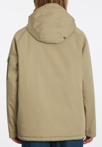 Beige, gewatteerde jas met een gladde textuur, voorzien van een verborgen naaddesign en een logo-label aan de achterzijde. Eenvoudige en functionele silhouet.