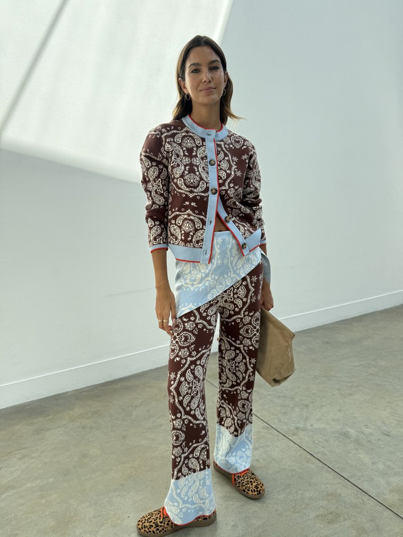 Braun und blau gemusterter Cardigan mit runden Knöpfen, kombiniert mit passenden Hosen mit einem Paisleymuster. Vervollständigt mit Leopardenmuster-Schuhen.