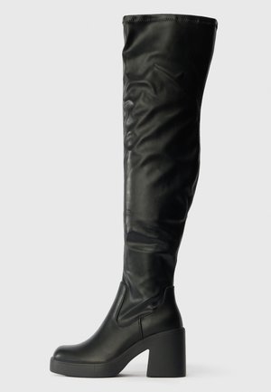 Over-the-knee black faux leather boots with a sleek design, chunky platform, and a rounded toe. Smooth texture and minimal stitching details.