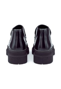 Bottes de cheville en cuir noir avec une finition brillante, dotées d'une semelle en caoutchouc épaisse et de détails texturés le long de l'arête.