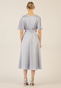 Hellblaues Satin-Kleid mit kurzen Ärmeln, tailliertem Gürtel und fließendem Rock. Die Rückseite verfügt über einen verdeckten Reißverschluss und einen mittel-langen Saum.