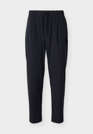 Pantalon décontracté noir pour homme avec ceinture élastique et cordon de serrage, doté de poches latérales et d'un discret patch logo sur la cuisse droite.